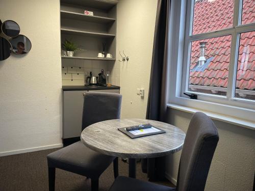 ein Raum mit einem Tisch und Stühlen und einem Fenster in der Unterkunft Hotel Willemstad in Willemstad