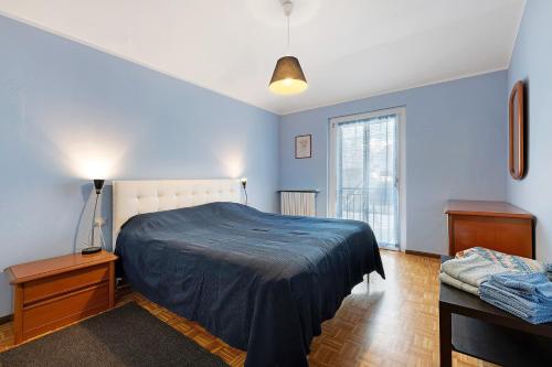 a bedroom with blue walls and a bed and a window at La dimora del Lago in Colico