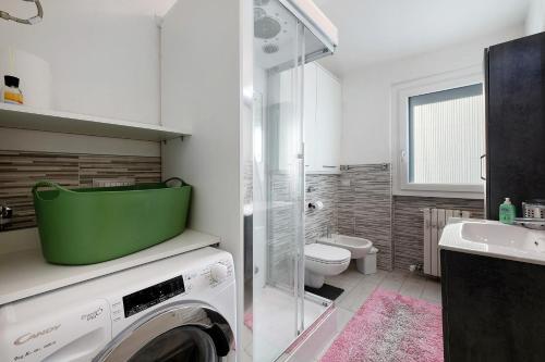 a bathroom with a washing machine and a toilet at La dimora del Lago in Colico