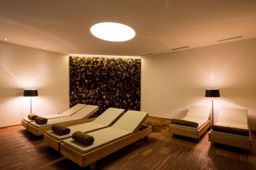 a living room with three couches and a wall at Hotel Klugbauer in Sommereben