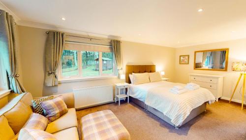 una camera da letto con un letto e un divano di Woodland House a Tomatin