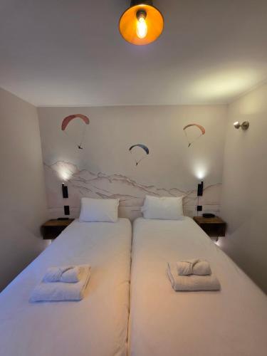 a bedroom with two beds with towels on them at Logis Hotel de l'Artuby in Séranon