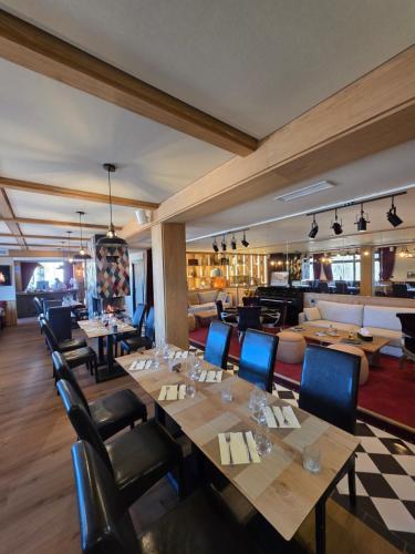 a restaurant with wooden tables and blue chairs at Logis Hotel de l'Artuby in Séranon