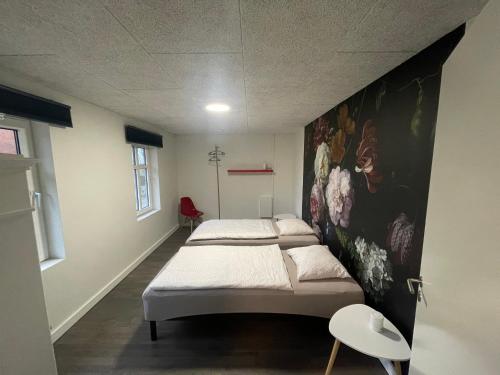 a room with two beds and a painting on the wall at Wohnung in Salling in Buksager