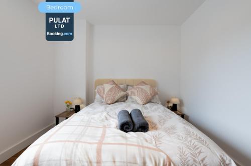 a person laying on a bed with their head on the pillows at 3BR Flat By Pulat Short Lets & Serviced Accommodation London With Pool Table, SmartTV & AC in London