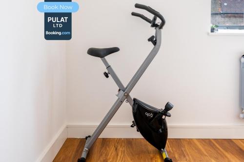 an exercise bike leaned against a wall with an umbrella at 3BR Flat By Pulat Short Lets & Serviced Accommodation London With Pool Table, SmartTV & AC in London