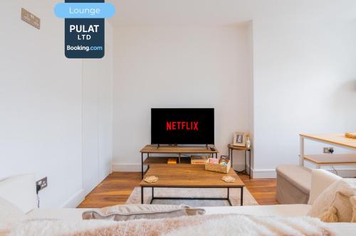 a living room with a tv and a coffee table at 3BR Flat By Pulat Short Lets & Serviced Accommodation London With Pool Table, SmartTV & AC in London