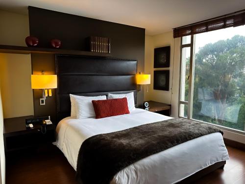 a bedroom with a large bed and a large window at Hotel Cabrera Imperial By key 33 in Bogotá