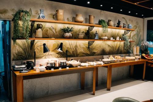 un bancone con sopra vasi e pentole di Portal Hotel Mogi Mirim a Mogi Mirim