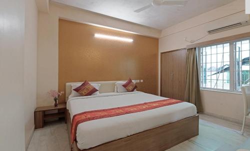 a bedroom with a large bed and a window at Hotel Sumandeep 