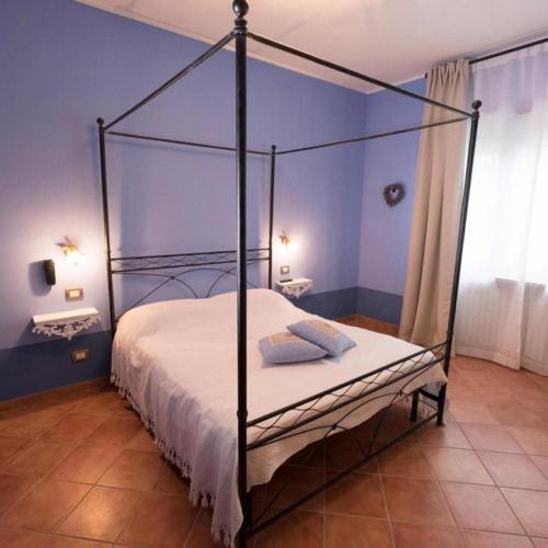 a bedroom with a canopy bed in a blue room at Agriturismo Villa Bordone in Villafranca dʼAsti