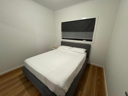 een slaapkamer met een bed en een flatscreen-tv bij Nine in Grovedale