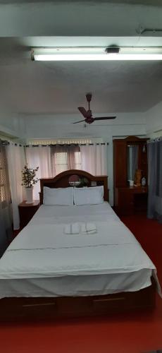 a bedroom with a large white bed with a ceiling at Thiramizhi in Ernakulam