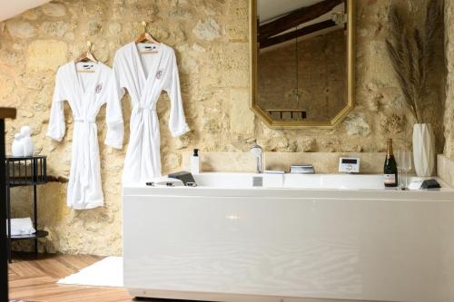 a white robe hanging on a wall next to a sink at Clos des Voluptés in Fargues-Saint-Hilaire