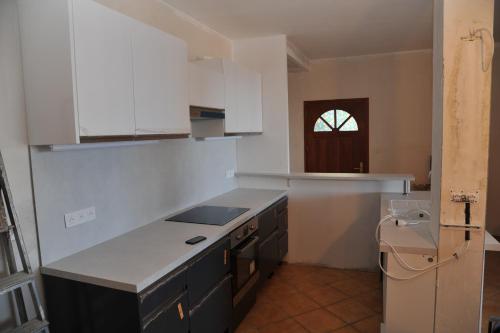 eine Küche mit weißen Schränken und einer Arbeitsplatte in der Unterkunft Vue mer 66 in Cerbère