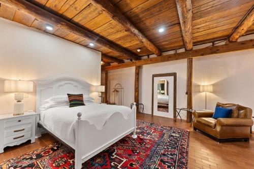 a bedroom with a white bed and a chair at Willow Street Cottages in Bluff