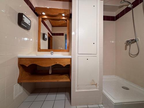 a bathroom with a sink and a mirror and a shower at Résidence Saboia Clés Blanches in La Tania