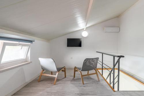 two chairs in a room with a desk and a window at Casa das Pipas Palmela #3 in Pinhal Novo