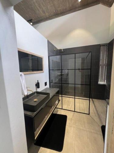a bathroom with a sink and a glass shower at Bluebell House@799 in Dullstroom