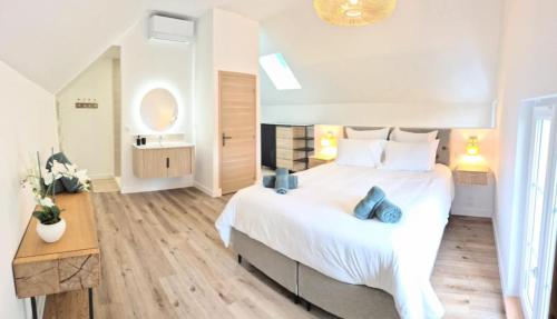 ein Schlafzimmer mit einem großen weißen Bett mit blauen Kissen in der Unterkunft Villa Margaux in Saint-Germain-sur-Vienne