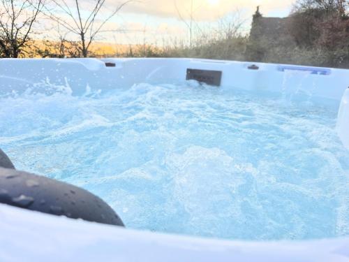 ein Whirlpool mit blauem Wasser darin in der Unterkunft Villa Margaux in Saint-Germain-sur-Vienne