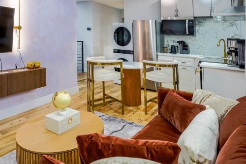 a living room with a couch and a table and a kitchen at Velvet Vue Suite Near JFK, UBS Arena, & 30mins from City in Bellerose Terrace