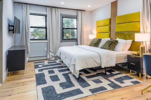 a bedroom with a large bed with a yellow headboard at Velvet Vue Suite Near JFK, UBS Arena, & 30mins from City in Bellerose Terrace