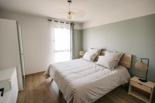 een slaapkamer met een bed met witte lakens en een raam bij Villa Moka - private pool in Saumane-de-Vaucluse