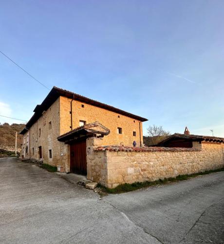 an old brick building on the side of a street at CASA RURAL PALACIO LOS LABREQUINES in Villacomparada de Rueda
