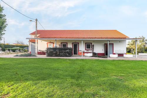 a small white house with a green yard at Casa das Pipas Palmela #2 in Pinhal Novo
