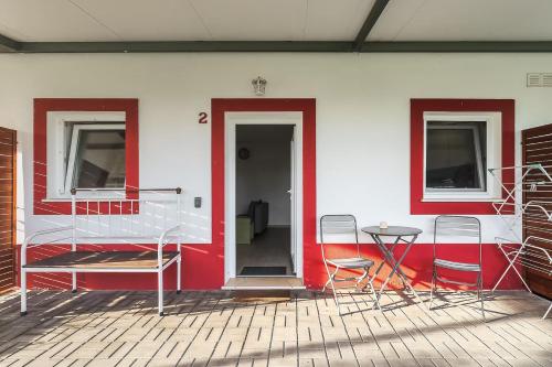 a red and white wall with chairs and a table at Casa das Pipas Palmela #2 in Pinhal Novo