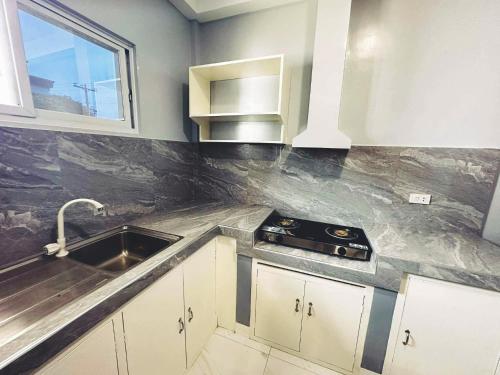 a kitchen with a sink and a stove at Casanuestra Apartelle in Panglao