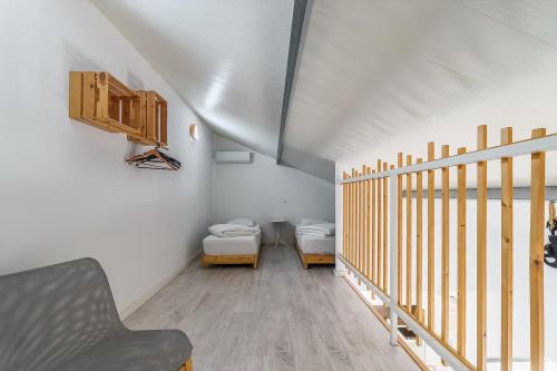 a attic room with two beds and a staircase at Casa das Pipas Palmela #2 in Pinhal Novo