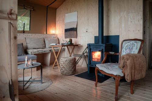 a living room with a wood stove and a couch at Smûk Thuskes in Echtenerbrug