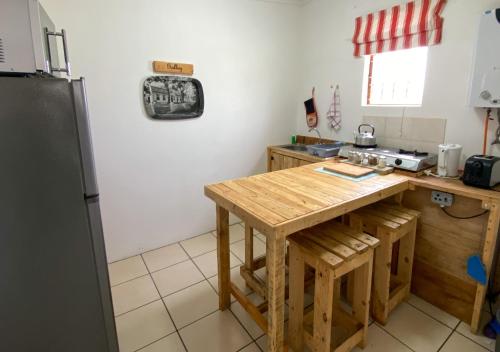 a kitchen with a wooden table and a refrigerator at Starboard Self Catering - St Helena Bay in Stompneusbaai