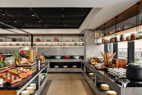 eine Küche mit einem Buffet mit Speisen in der Unterkunft Ramada Encore by Wyndham Gurugram Dwarka Expressway in Gurgaon