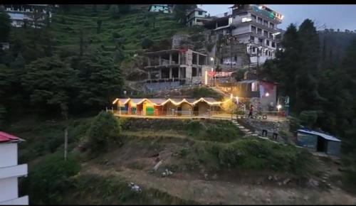 a house on top of a hill with a building at Himalayan Wooden Cottage & Cafe Dalhousie in Dalhousie