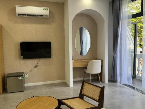 sala de estar con TV y espejo en StayLa Homestay, en Phu Quoc