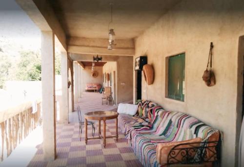 a living room with a couch and a table at Auberge jawahir aguerd 