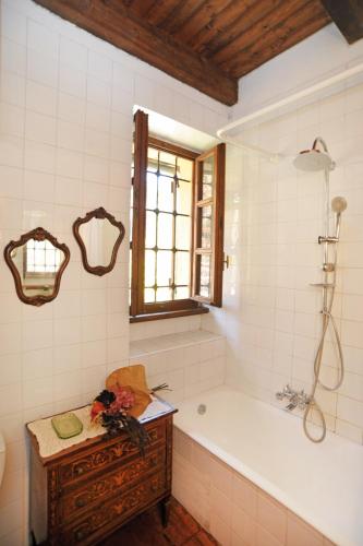 a bathroom with a tub and a sink and a window at Il portico sulla valle, Bioglio in Valle San Nicolao