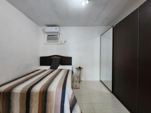 ein Schlafzimmer mit einem Bett mit einer gestreiften Decke in der Unterkunft Casa Praia Alegre in Penha