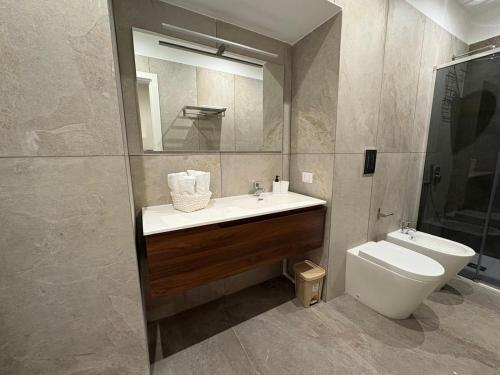 a bathroom with a sink and a toilet and a mirror at Andrea House in Naples