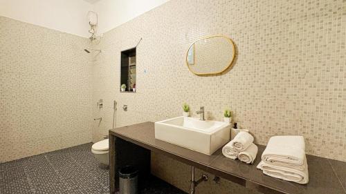 a bathroom with a sink and a toilet and a mirror at CocoAura - Tropical Luxury Villa with Pool&Jacuzzi in Utan