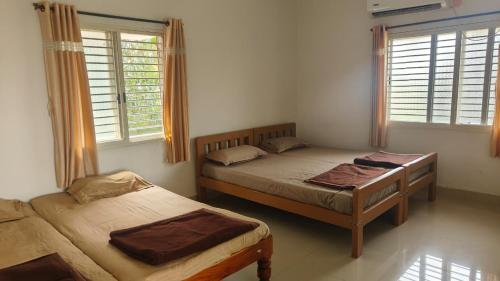Serene Homestay في بادامي: سريرين في غرفة ذات نافذتين