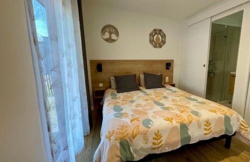Un dormitorio con una cama grande y una ventana. en Charming ecolodge with heated pool all year round, en Les Mathes