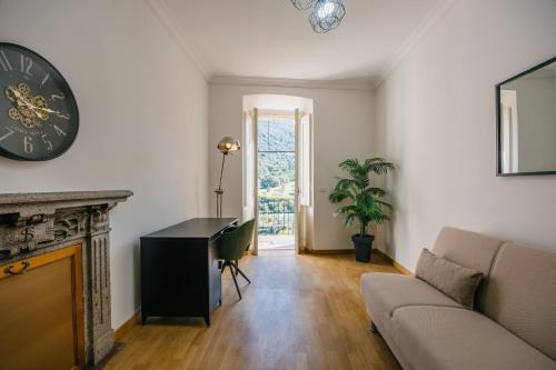 een woonkamer met een bank en een klok aan de muur bij BHR - La Finestra su Spoleto in Spoleto