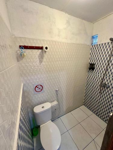a bathroom with a white toilet in a room at Rodin Bali Hostel in Seminyak