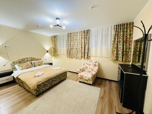 ein Hotelzimmer mit einem Bett und einem Stuhl in der Unterkunft TwinHouse Karakol in Karakol