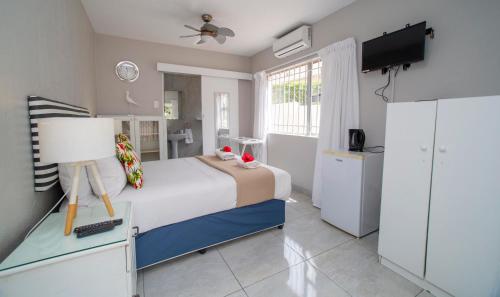 a bedroom with a bed and a tv in it at 1 Seabreeze Cottage in Durban