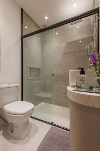 a bathroom with a toilet and a glass shower at Apartamento 401 wiithhoeftf in Pomerode
